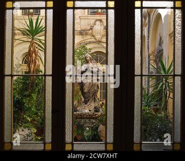 Une cour intérieure de l'église Saint François d'Assise à la Valette, Malte, est représentée par des fenêtres en verre teinté et au plomb. Banque D'Images