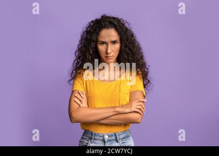 Une femme grincheux. Portrait d'une femme offense sérieuse debout avec des bras croisés Banque D'Images