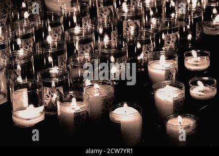 Flammes de la foi : des bougies votives scintillant illuminent de petits espaces à l'intérieur sombre de la Basilique Sainte-Marie-Madeleine (Basilique Sainte-Marie-Madeleine) à Vézelay, Yonne, Bourgogne, Bourgogne-Franche-Comté, France. La basilique est l'église d'une ancienne abbaye bénédictine reconstruite et agrandie au XIIe siècle pour faire face à des hordes de pèlerins voyageant vers des os vénérés conservés dans la crypte, considérés comme des reliques de Sainte Marie-Madeleine. Banque D'Images