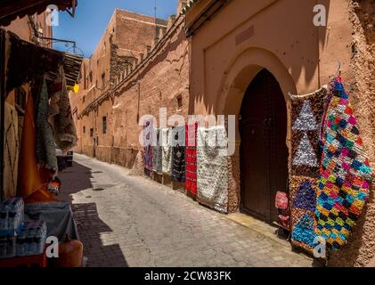 Tapis à vendre suspendus dans la rue. Mur d'allée typique à la Médina de Marrakech. Banque D'Images