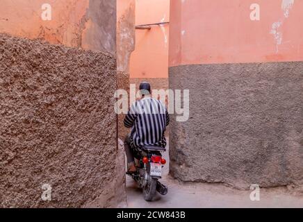 Motard dans la rue étroite de Medina. Les scooters sont le moyen de transport typique à Marrakech. Banque D'Images