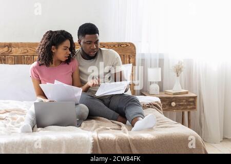 Un jeune couple afro-américain vérifie le budget familial le week-end Banque D'Images