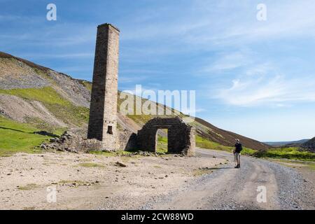 Un marcheur sur la promenade d'un océan à l'autre en passant par le Old Gang Eperlan Mill, un moulin à éperlan de plomb sur Reeth High Moor, dans le North Yorkshire, en Angleterre, au Royaume-Uni Banque D'Images