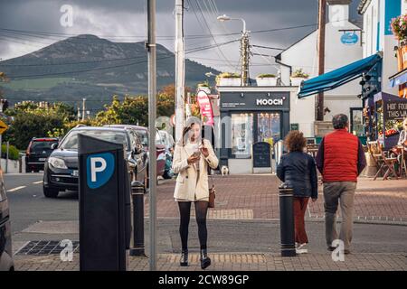 Vie quotidienne. La jeune fille tend la main vers la caméra avec son téléphone dans ses mains. Greystones. Irlande. Banque D'Images