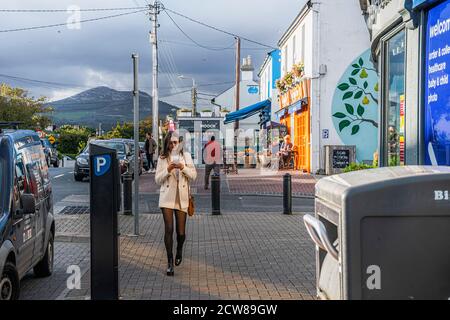 Vie quotidienne. La jeune fille tend la main vers la caméra avec son téléphone dans ses mains. Greystones. Irlande. Banque D'Images