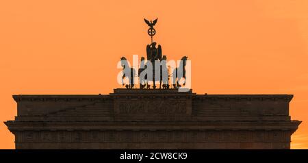 Coucher de soleil à la porte de Brandebourg (en allemand : Brandenburger Tor), un monument néoclassique du XVIIIe siècle à Berlin, en Allemagne. Une Quadriga se trouve en haut de la porte, Banque D'Images