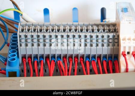 Bornier gris avec fils rouges connectés. Banque D'Images