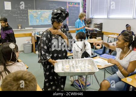 Pflugerville, TX 2 juin 2008 : un étudiant afro-américain livre de la nourriture nigériane ethnique à des camarades de classe lors de la célébration annuelle de la Journée de la diversité à la Park Crest Middle School, qui propose de la nourriture ethnique, des sketch, des lectures de poésie et de la musique pour les élèves de sixième à huitième année. ©Bob Daemmrich Banque D'Images