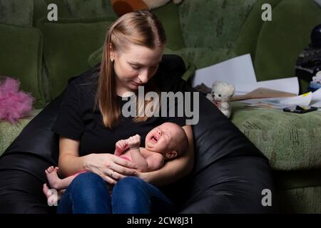 Jeune mère avec un nouveau-né en pleurs. Banque D'Images