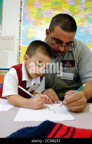 Un programme de San Antonio, Texas, à la pré-école de Head Start offre un dîner gratuit et du temps en famille pour les jeunes enfants et leurs parents. Après le dîner, les adultes se rencontrent pour une séance de conseil de groupe sur les techniques parentales réussies, puis se joignent à leurs enfants pour lire et écrire ensemble. ©Bob Daemmrich Banque D'Images