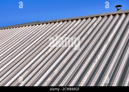 Texture du toit d'une maison assemblée en galvanisée repassez les draps dans un ciel bleu Banque D'Images