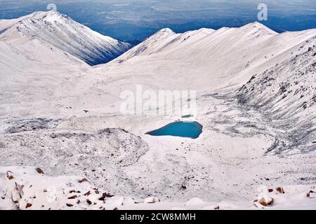 Lac de Moraine dans les sommets supérieurs d'une gorge de montagne après une chute de neige récente; notion de pureté des ressources en eau Banque D'Images