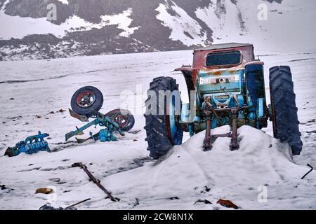 Pièces démontées de l'ancien tracteur en tant que déchets et pollution sur un glacier de montagne; concept de problèmes environnementaux Banque D'Images