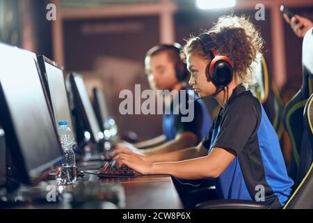 Équipe de gamers professionnels adolescents participant au tournoi eSports, jouant à des jeux vidéo en ligne Banque D'Images