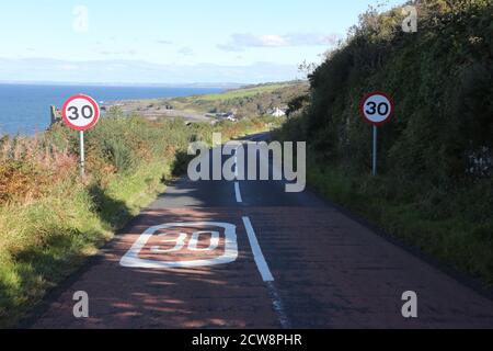 Dunure, Ayrshire, Écosse, Royaume-Uni.Castel Road qui mène au village de pêcheurs de Dunure montrant des panneaux de vitesse de 30 MPH sur la raode et le début du village Banque D'Images