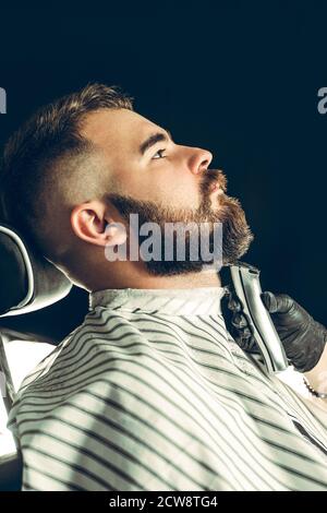 Client Barbershop. Homme taillé sa barbe avec un rasoir électrique Banque D'Images