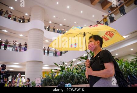 Un manifestant portant un masque facial est vu tenir un parapluie démocratique pendant la manifestation pour commémorer le 6ème anniversaire du mouvement Umbrella.des dizaines de manifestants pro-démocratie se sont rassemblés dans le centre commercial Pacific place à Hong Kong pour marquer le 6ème anniversaire du mouvement Umbrella où Hong Kongers ont pris dans la rue et a occupé les routes principales de la ville pour exiger le suffrage universel. Banque D'Images