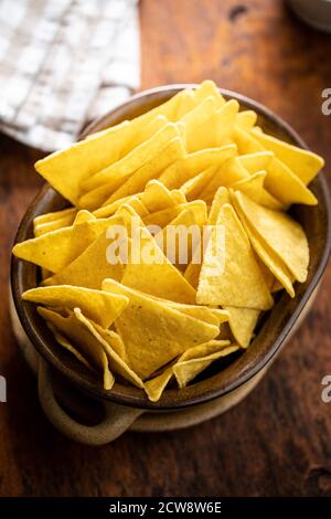 Croustilles tortilla salées dans un bol sur une table en bois. Banque D'Images