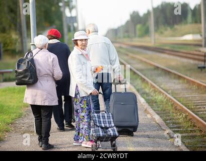 groupe d'aînés personnes âgées âgées avec bagages en attente un train pour voyager Banque D'Images