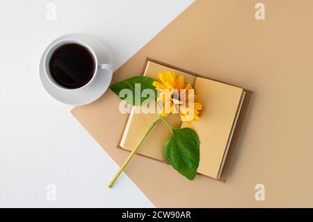 Planificateur de cahier pour le travail, tasse de café, fleur de tournesol jaune. Pose à plat. Copier l'espace. Banque D'Images