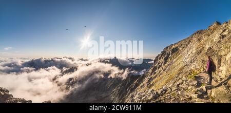 Tourisme regardant sur la vallée de Mengusovska avec inversion tout en randonnée jusqu'au pic de Rysy à High Tatras, Slovaquie Banque D'Images