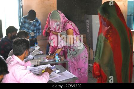 Beawar, Rajasthan, Inde, 28 septembre 2020 : Rajasthani, une femme voilée, a voté à un bureau de vote lors des élections de Panchayati Raj, dans le contexte de la pandémie du coronavirus, dans le village de Jala ki Chauki près de Beawar. Plus de 83.50 pour cent des électeurs de 31.95-lakh ont voté dans la première phase des 947 grammes panchayat (conseil de village) des élections dans 25 districts de l'État. Les lignes directrices relatives à la COVID-19 n'ont pas été suivies pendant l'élection. Les électeurs portent un masque facial, mais n'ont pas maintenu de distanciation sociale. Crédit : Sumit Saraswat/Alay Live News Banque D'Images