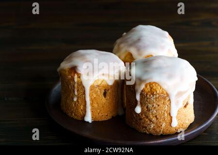 Pâte traditionnelle de Pâques au kulich servie sur une assiette marron foncé. Table en bois, haute résolution Banque D'Images