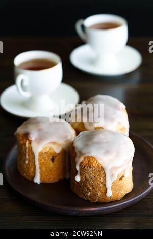 Pâtisserie traditionnelle de Pâques au kulich servie avec des tasses de thé en porcelaine blanche. Table en bois, haute résolution Banque D'Images