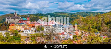 Vue panoramique aérienne de la ville médiévale de Loket avec le château de Loket de style gothique Hrad Loket sur de gigantesques bâtiments colorés. Panorama de la ville de Loket et des collines forestières en automne, République tchèque Banque D'Images