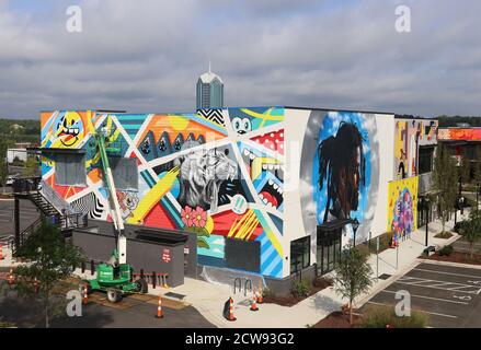 Durham, Caroline du Nord, États-Unis. 28 septembre 2020. L'artiste GREG MIKE d'Atlanta, GA travaille sur sa murale à Ã”UHill Walls,Ã une expérience d'art dense et facile à marcher avec plus de 40,000 pieds carrés de peintures murales sur 15 acres contigus à Durham, Caroline du Nord.en septembre, quarante-deux local, Des artistes nationaux et internationaux créeront l'une des plus grandes collections consolidées de peintures murales dans le sud-est des États-Unis.Ã”UHill WallsÃ sera la force motrice derrière University Hill, un réaménagement à usage mixte d'un centre de strip abandonné avec des aliments, des boissons, le bien-être et la vie résidentielle primés. (Image crédit : © Banque D'Images