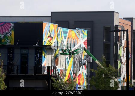 Durham, Caroline du Nord, États-Unis. 28 septembre 2020. L'artiste GREG MIKE d'Atlanta, GA travaille sur sa murale à Ã”UHill Walls,Ã une expérience d'art dense et facile à marcher avec plus de 40,000 pieds carrés de peintures murales sur 15 acres contigus à Durham, Caroline du Nord.en septembre, quarante-deux local, Des artistes nationaux et internationaux créeront l'une des plus grandes collections consolidées de peintures murales dans le sud-est des États-Unis.Ã”UHill WallsÃ sera la force motrice derrière University Hill, un réaménagement à usage mixte d'un centre de strip abandonné avec des aliments, des boissons, le bien-être et la vie résidentielle primés. (Image crédit : © Banque D'Images