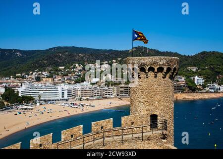 Le drapeau d'indépendance catalan volant des murs du château médiéval de Tossa de Mar sur la Costa Brava en Catalogne, Espagne Banque D'Images