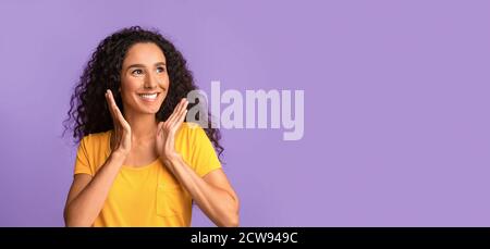 Offre intéressante. Une Brunette souriante qui regarde l'espace de copie avec enthousiasme Banque D'Images