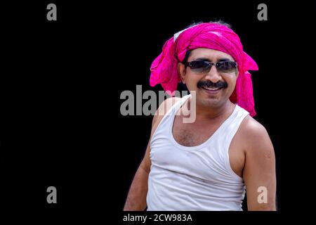 Couvrez la tête d'un homme portant une coiffe rose et des lunettes de soleil avec un sourire sur son visage Banque D'Images