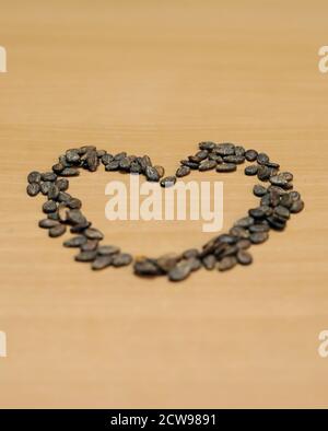 Forme de coeur faite de graines de pastèque, composition isolée sur les tables en bois Banque D'Images
