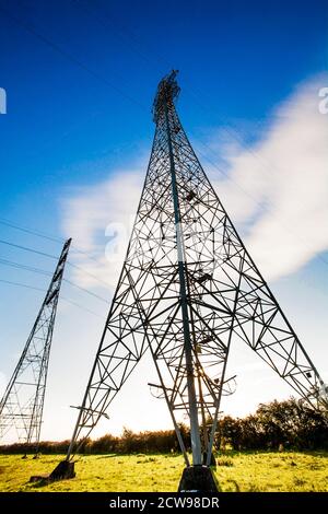 Pylônes d'électricité dans un cadre rural avec un ciel bleu. Banque D'Images