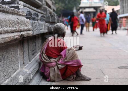 La vieille femme mendiant assis à l'intérieur d'un temple Banque D'Images