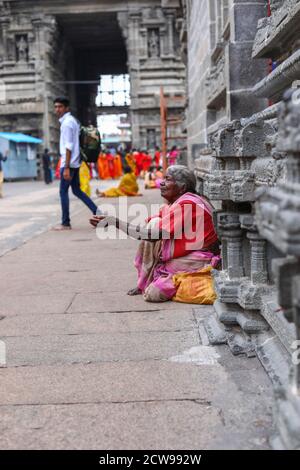 La vieille femme mendiant assis à l'intérieur d'un temple Banque D'Images