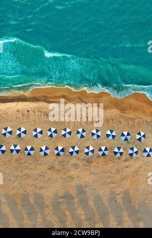 Plage vide, vue sur les drones. Parasols, eau bleue et sable doré Banque D'Images