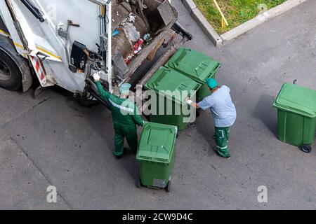 les poubelles chargent les ordures ménagères dans un camion à ordures, vue d'en haut Banque D'Images