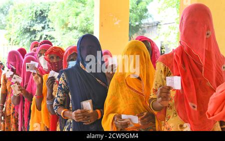 Rajasthani a vu des femmes voilées attendre dans de longues files d'attente pour voter dans un bureau de vote lors des élections de Panchayati Raj, dans le contexte de la pandémie du coronavirus, dans le village de Sendra près de Beawar. Plus de 83.50 pour cent des électeurs de 31.95-lakh ont voté dans la première phase des 947 grammes panchayat (conseil de village) des élections dans 25 districts de l'État. Les lignes directrices relatives à la COVID-19 n'ont pas été suivies pendant l'élection. Les électeurs portent un masque facial, mais n'ont pas maintenu de distanciation sociale. (Photo de Sumit Saraswat/Pacific Press) Banque D'Images