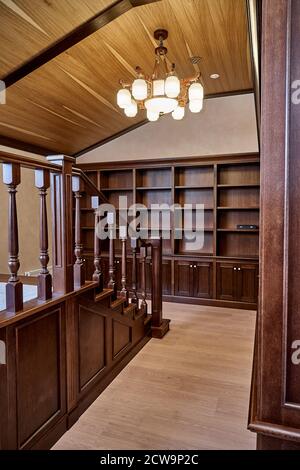 Bibliothèque personnelle. Bibliothèque en bois avec des étagères vides et une balustrade en bois placée dans la maison bibliothèque dans la maison Banque D'Images