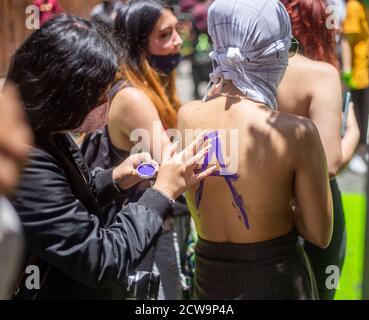 Bogota, Colombie. 27 septembre 2020. Une femme peint le dos d'une autre femme. À la tête de la Cour suprême de Colombie, ils se sont rencontrés pour démontrer la légalisation des avortements dans le pays, une partie de la protestation a été de couvrir avec de la peinture verte un ancien graffiti fait par les partisans de non-avortement. Crédit : Daniel Garzon Herazo/ZUMA Wire/Alay Live News Banque D'Images