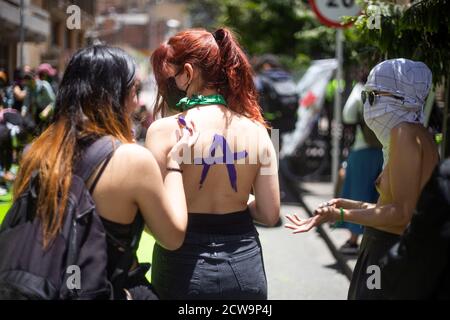 Bogota, Colombie. 27 septembre 2020. Une femme peint le dos d'une autre femme. À la tête de la Cour suprême de Colombie, ils se sont rencontrés pour démontrer la légalisation des avortements dans le pays, une partie de la protestation a été de couvrir avec de la peinture verte un ancien graffiti fait par les partisans de non-avortement. Crédit : Daniel Garzon Herazo/ZUMA Wire/Alay Live News Banque D'Images