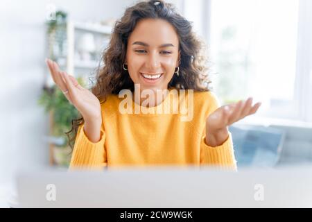 Une jeune femme utilise un ordinateur portable. Drôle de fille ayant le plaisir de rester à la maison. Banque D'Images