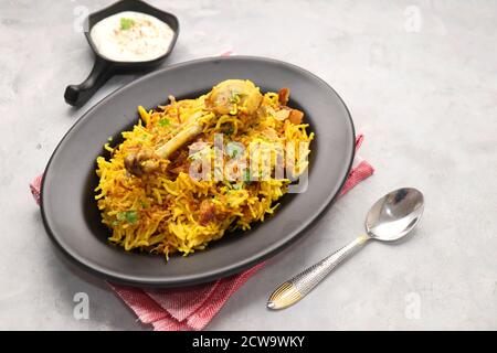 Poulet Biryani, poulet Pulav. Garniture à l'oignon frit et à la coriandre. Biryani servi avec raita est un célèbre plat de riz non végétarien épicé de l'Inde. Banque D'Images