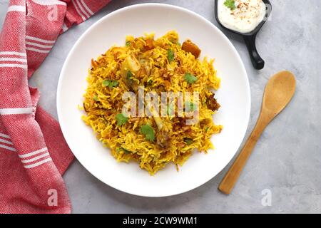 Poulet Biryani, poulet Pulav. Garniture à l'oignon frit et à la coriandre. Biryani servi avec raita est un célèbre plat de riz non végétarien épicé de l'Inde. Banque D'Images