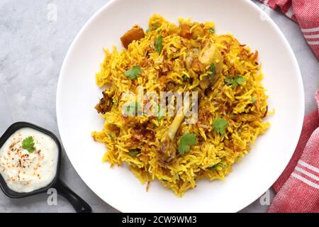 Poulet Biryani, poulet Pulav. Garniture à l'oignon frit et à la coriandre. Biryani servi avec raita est un célèbre plat de riz non végétarien épicé de l'Inde. Banque D'Images