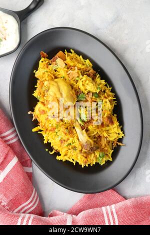 Poulet Biryani, poulet Pulav. Garniture à l'oignon frit et à la coriandre. Biryani servi avec raita est un célèbre plat de riz non végétarien épicé de l'Inde. Banque D'Images