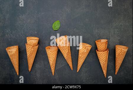 Mise à plat des glaces collection sur pierre sombre contexte . Croustillant blanc ice cream cone avec copie espace pour les dragées menu design. Banque D'Images
